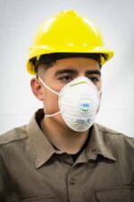 Trabajador con casco de seguridad usando mascarilla N95 con válvula de exhalación UCU232R De Pascale en entorno industrial