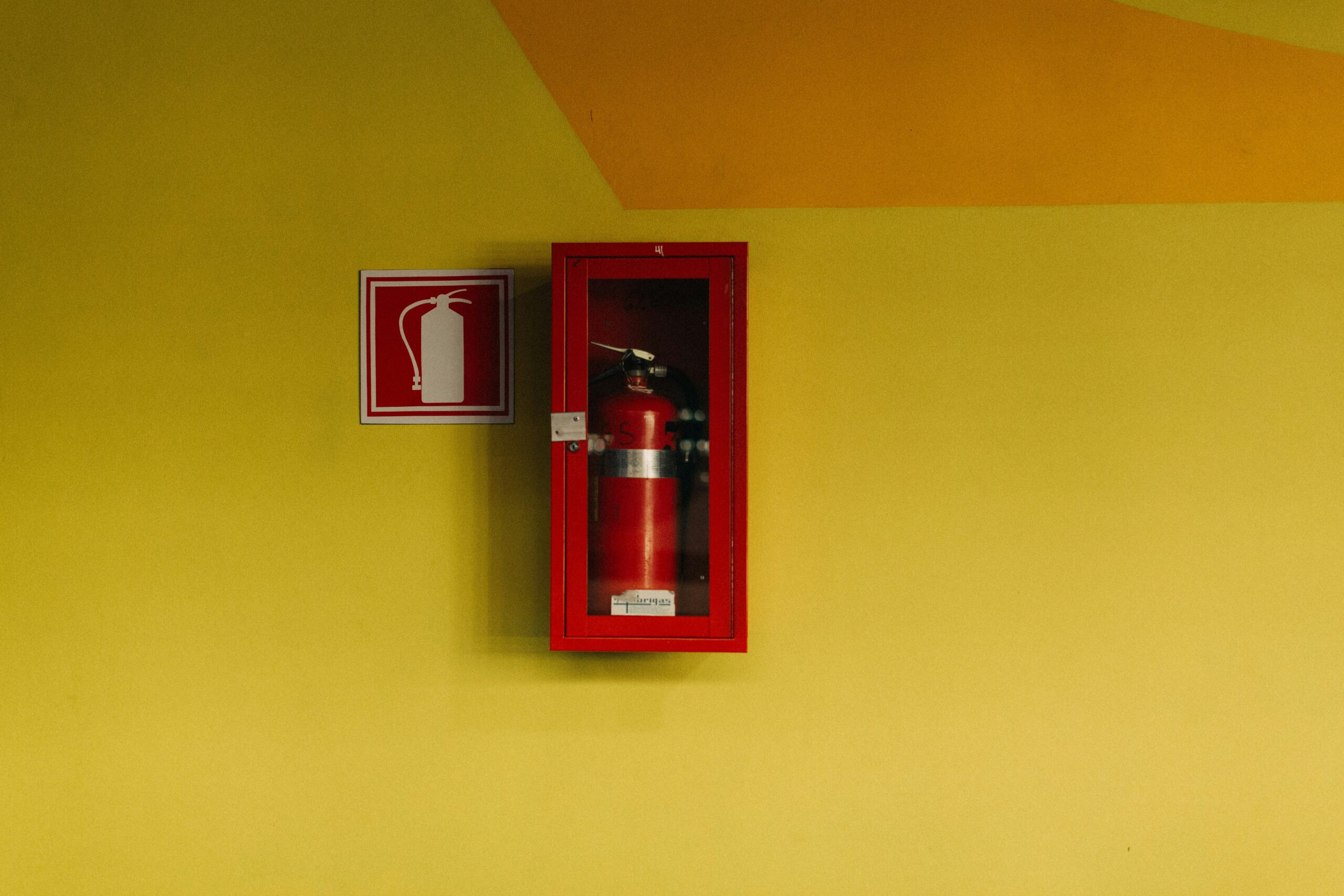 Fotografía de una pared con extintor en un comercio gastronómico.