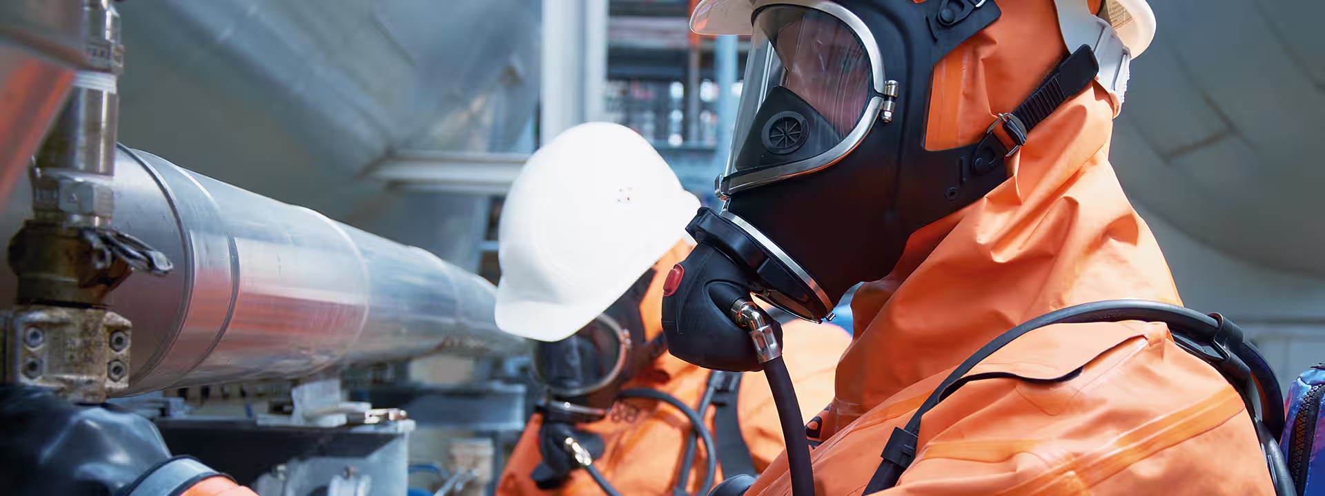 Máscara de protección respiratoria drager con operario industrial con traje narnaja.