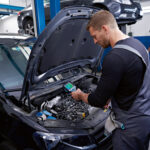 Técnico en taller mecánico utilizando la termocámara Bosch PRO GTC 600 C para inspeccionar el motor de un vehículo.