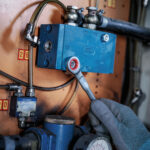 Operario utilizando la llave con crique Bosch PRO de 13 mm en un componente hidráulico industrial.