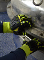 Operario trabajando en una instalación industrial utilizando los guantes anti impacto DP DPS87485X.