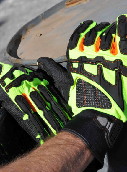 Operario utilizando los guantes anti impacto DP DPS83685X en un entorno de trabajo industrial.